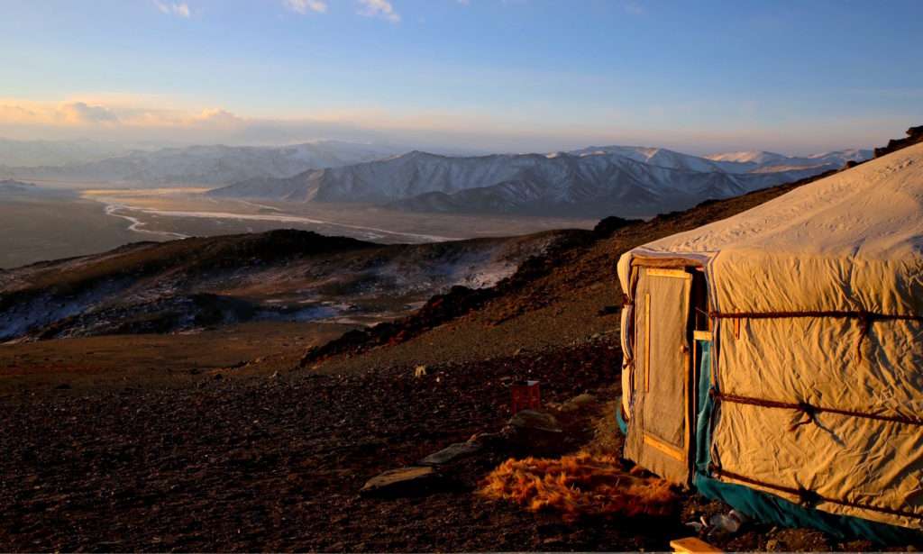 Das winterliche Altai-Gebirge in der Westmongolei. Die Sonne strahlt bei tiefen Minustemperaturen ein warmes Licht aus.